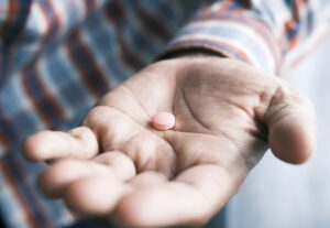 Mano que ofrece una pastilla: el efecto placebo y el efecto nocebo
